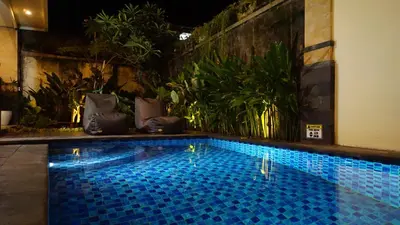 a swimming pool in the middle of a room at BAGUS Guest House in Legian