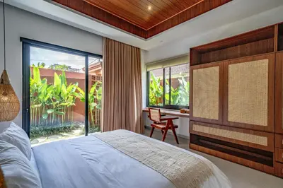 a bedroom with a bed and a large window at Casa Umari in Canggu