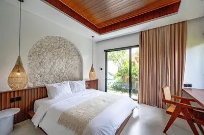 a bedroom with a large bed and a large window at Casa Umari in Canggu