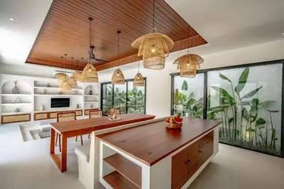 a dining room with a table and a large aquarium at Casa Umari in Canggu