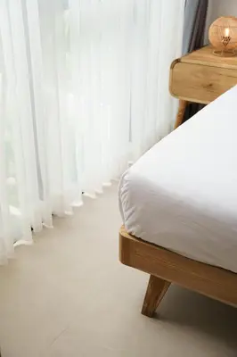 a bed in a room with white curtains at Mau Villa by Bali Bliss Properties in Canggu
