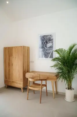 a wooden table and a potted plant in a room at Mau Villa by Bali Bliss Properties in Canggu