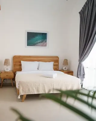 a bedroom with a bed with a wooden headboard at Mau Villa by Bali Bliss Properties in Canggu