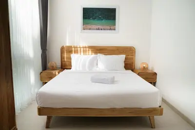 a bedroom with a bed with white sheets and pillows at Mau Villa by Bali Bliss Properties in Canggu