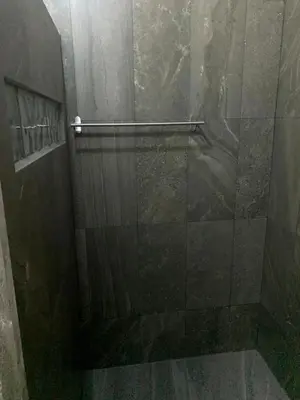 a shower with a glass door in a bathroom at Villa D Lima Top Floor in Kuta