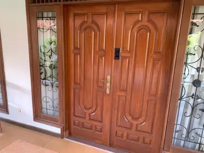 a pair of wooden doors in a house at Villa D Lima Top Floor in Kuta