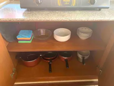 a kitchen shelf with bowls and dishes on it at Villa D Lima Top Floor in Kuta