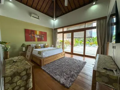 a bedroom with a large bed and a large window at Party Size 4 Bedroom Villa Kerobokan in Seminyak