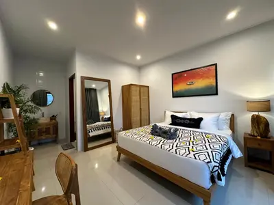 a bedroom with a large bed and a mirror at 2 bedrooms villa cinta umalas in Kerobokan