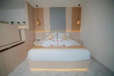 a bedroom with a large bed with white sheets at Dikubu Bali Villa and Suites in Kerobokan