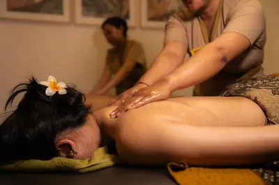 a woman giving a man a back massage at Dikubu Bali Villa and Suites in Kerobokan