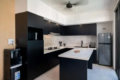 a kitchen with black cabinets and a refrigerator at Villa Biku in Umalas