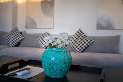 a blue vase with flowers on a table in a living room at Villa Biku in Umalas