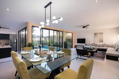 a dining room and living room with a table and chairs at Villa Biku in Umalas