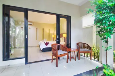 a patio with two chairs and a table and a couch at Kefi Villa Seminyak in Seminyak