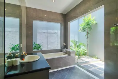 a bathroom with a sink and a tub and a window at Kefi Villa Seminyak in Seminyak