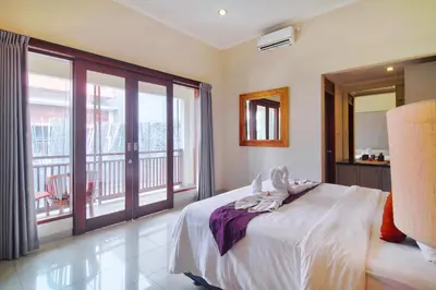 a bedroom with a large bed and a balcony at Kefi Villa Seminyak in Seminyak