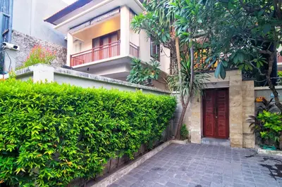 a house with a red door and a hedge at Kefi Villa Seminyak in Seminyak