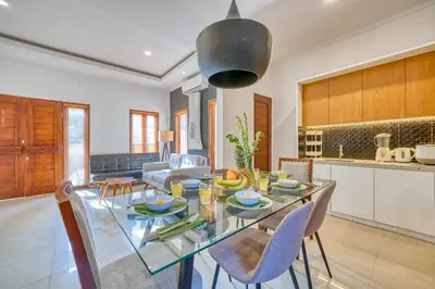 a kitchen and living room with a glass table and chairs at 3 Bd Pvt House with big common pool and Gym in Nusa Dua
