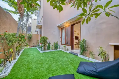 a backyard with green grass and plants at 3 Bd Pvt House with big common pool and Gym in Nusa Dua