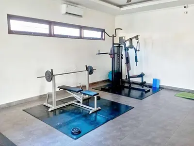 a gym with two treadmills and machines in a room at 3 Bd Pvt House with big common pool and Gym in Nusa Dua