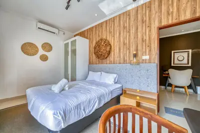 a bedroom with a bed and a desk and a chair at 3 Bd Pvt House with big common pool and Gym in Nusa Dua