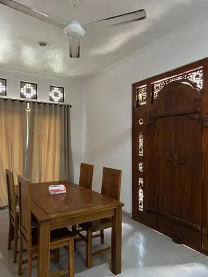 a dining room with a wooden table and chairs at Pondok Ledog 01 in Badung