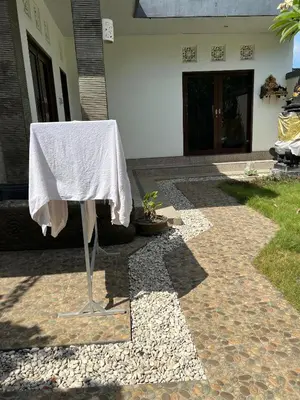 a table with a white table cloth sitting on a patio at Pondok Ledog 01 in Badung