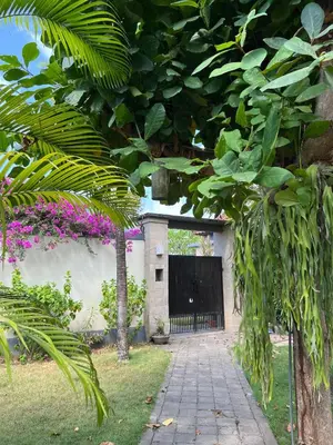 a driveway leading to a garage with a black door at Pondok Ledog 01 in Badung