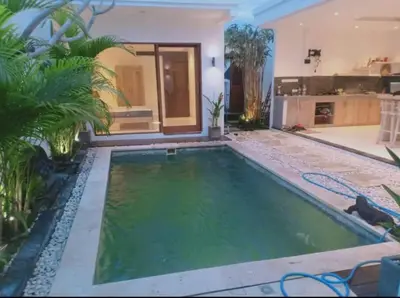 a swimming pool in a backyard with a house at Villa umara 2 kerobokan close to seminyak in Seminyak