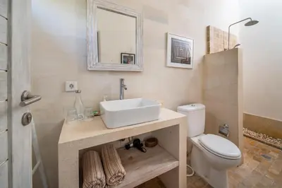 a bathroom with a sink and a toilet at Villa Tara by Villa Finder in Seminyak