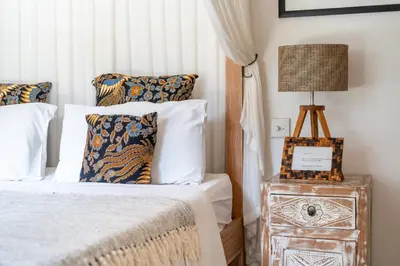 a bedroom with a bed and a lamp on a night stand at Villa Tara by Villa Finder in Seminyak