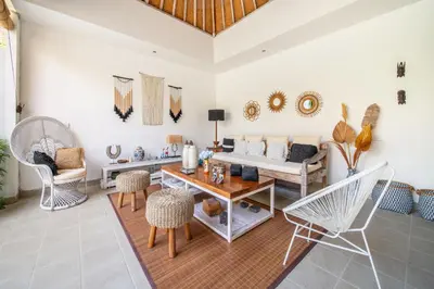 a living room with a couch and a table and chairs at Villa Tara by Villa Finder in Seminyak