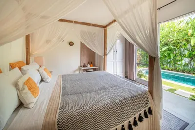 a bedroom with a bed and a large window at Villa Tara by Villa Finder in Seminyak