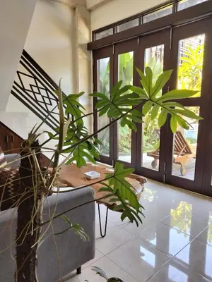 a living room with a table and some plants at Shira House Bali in Legian