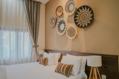 a bedroom with a bed and plates on the wall at Shira House Bali in Legian