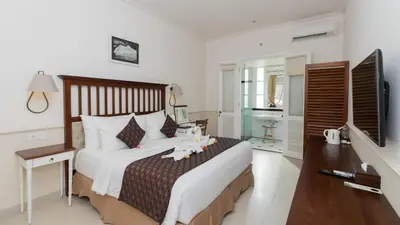 a bedroom with a large bed with a desk and a bed at SOLTERRA SEMINYAK Boutique Hotel & Spa Powered by Archipelago in Seminyak