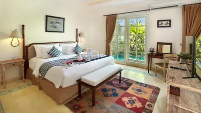 a bedroom with a large bed and a room with a table at SOLTERRA SEMINYAK Boutique Hotel & Spa Powered by Archipelago in Seminyak