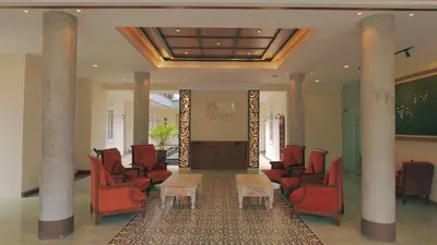 a waiting room with red chairs and a table at SOLTERRA SEMINYAK Boutique Hotel & Spa Powered by Archipelago in Seminyak