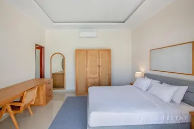 a bedroom with a white bed and a wooden desk at Two Bedroom Villa with Outdoor Pool in Umalas