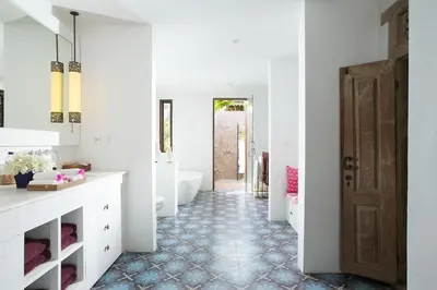a bathroom with a tub and a toilet and a sink at Villa MAMOUNE in Canggu
