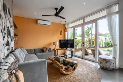 a living room with a couch and a tv at Athos Villa by iBali Management in Seminyak