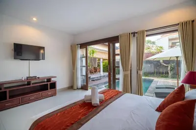 a bedroom with a large bed and a television at Kusuma Coliving & Villas in Canggu