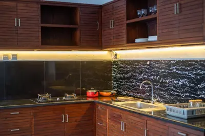a kitchen with wooden cabinets and a sink at Kusuma Coliving & Villas in Canggu