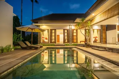 a villa with a swimming pool and a house at Kusuma Coliving & Villas in Canggu