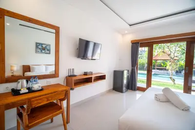 a bedroom with a bed and a desk and a mirror at Kusuma Coliving & Villas in Canggu