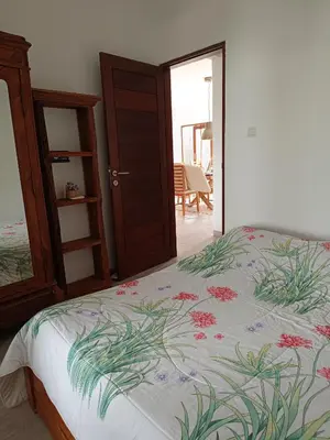 a bedroom with a bed with flowers on it at Casa Dijaweqo in Jimbaran