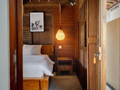 a small bedroom with a bed and a pendant light at Bale Bali Batubelig by ARM Hospitality in Canggu