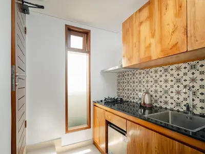 a kitchen with a sink and a window at Bale Bali Batubelig by ARM Hospitality in Canggu