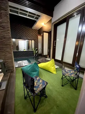 a living room with two chairs on a green carpet at MOOvilla 1 Seminyak, Bali in Umalas